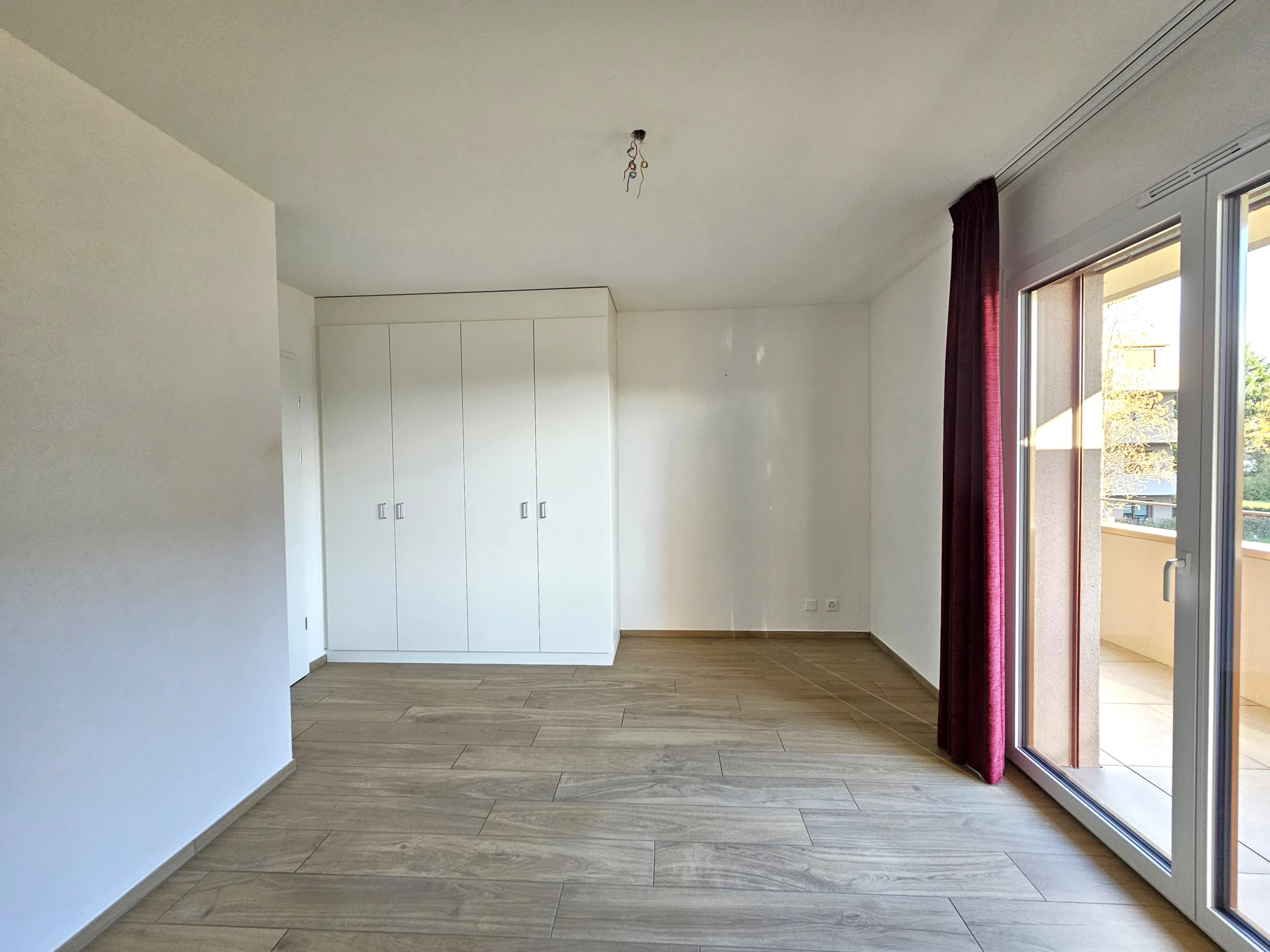 Helles Schlafzimmer mit Einbauschrank und Balkonzugang
