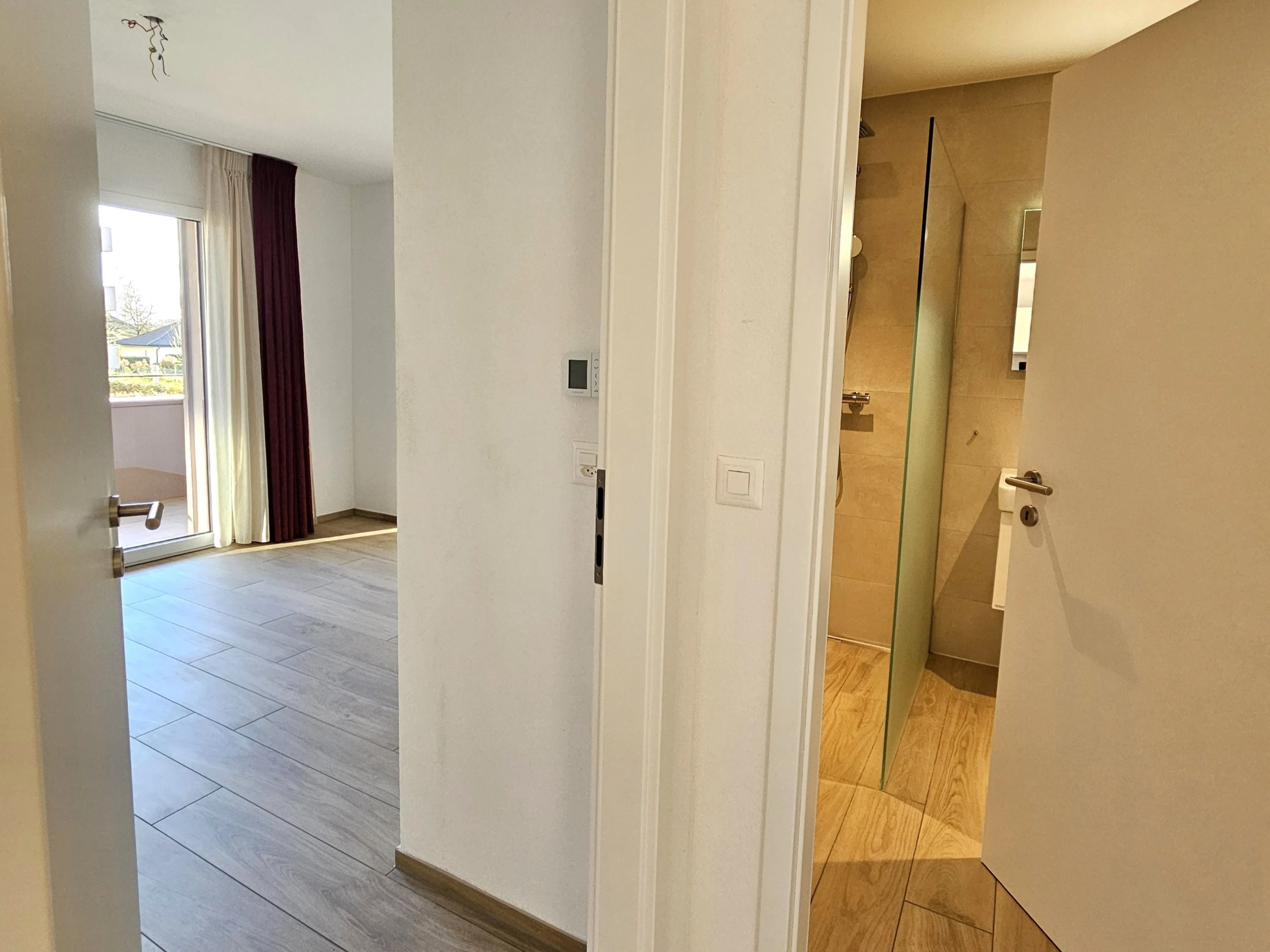 Heller Flur mit Blick in Wohnraum und Badezimmer