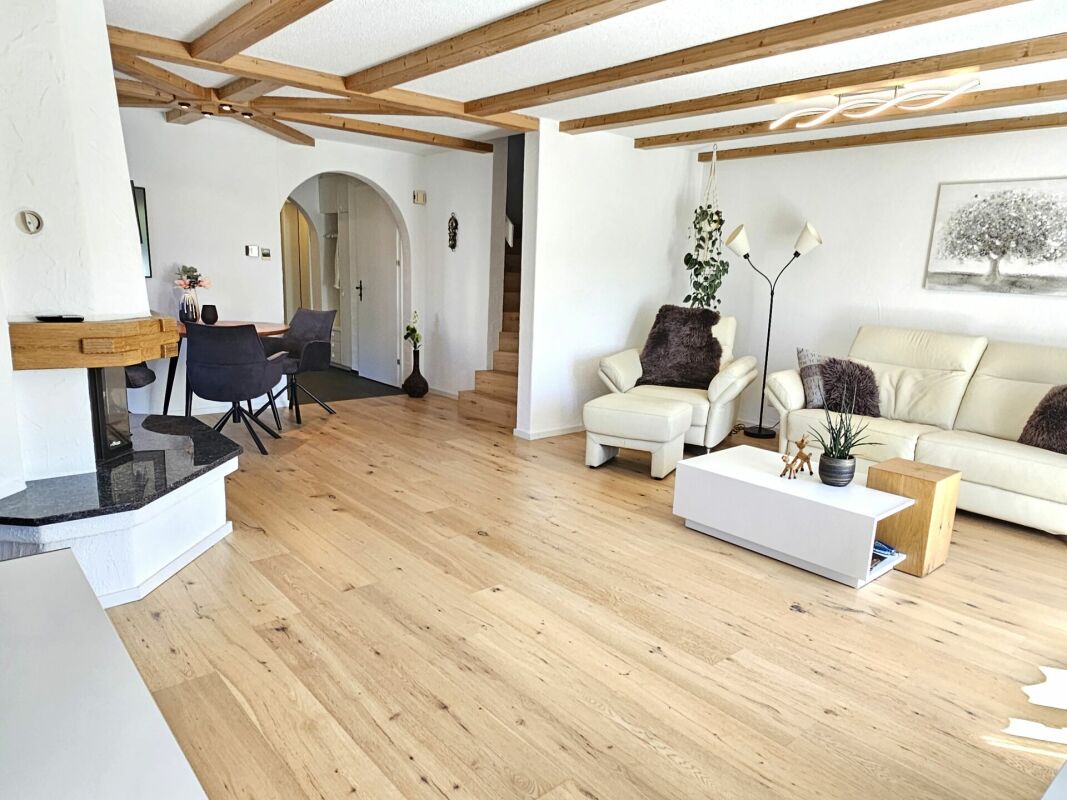 Offener Wohnbereich mit Holzdecke und Kamin