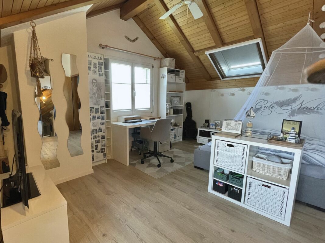 Dachzimmer mit Arbeitsplatz und Bett