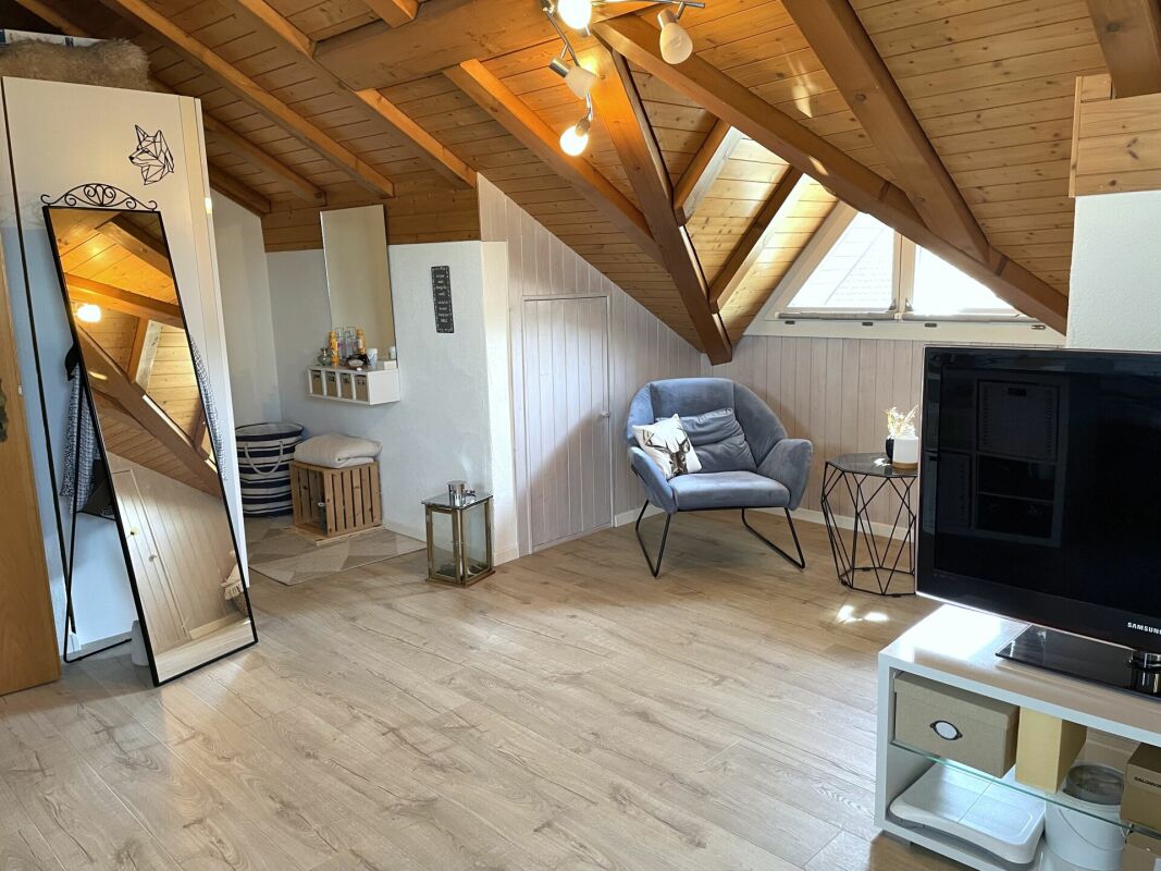 Gemütlicher Dachgeschoss-Wohnraum mit Holzdecke und Velux-Fenster
