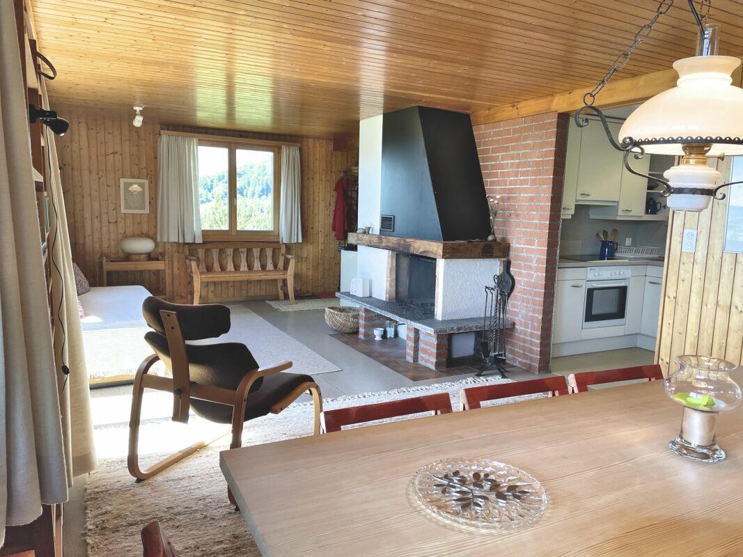 Gemütliches Wohn-Esszimmer mit Kamin und Holzvertäfelung