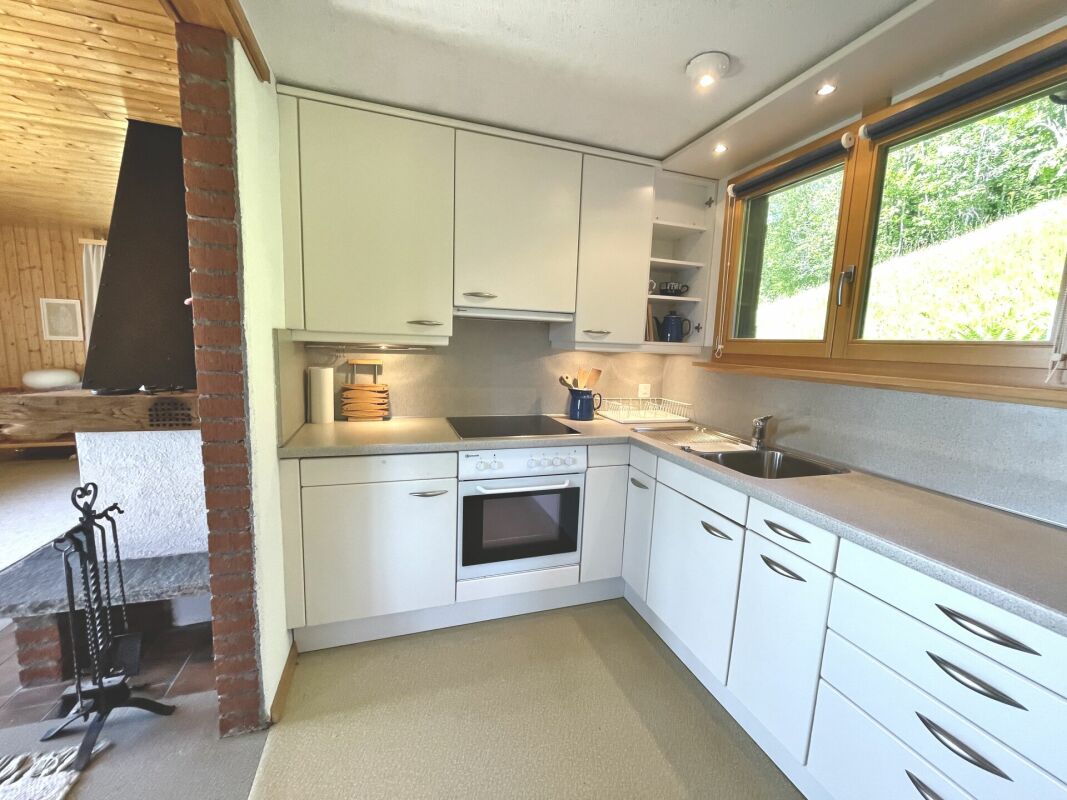 Helle Einbauküche mit Holzfenster und Holzdecke