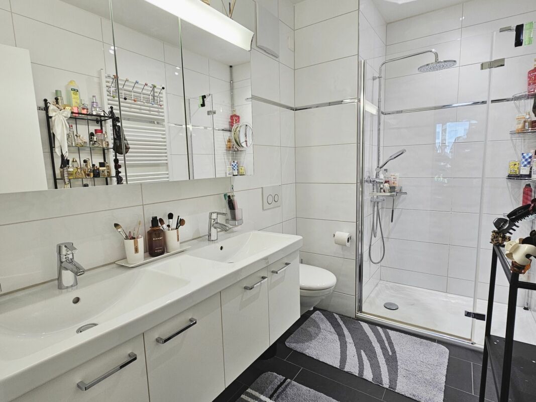 Modernes Badezimmer mit Doppelwaschtisch und Glasdusche