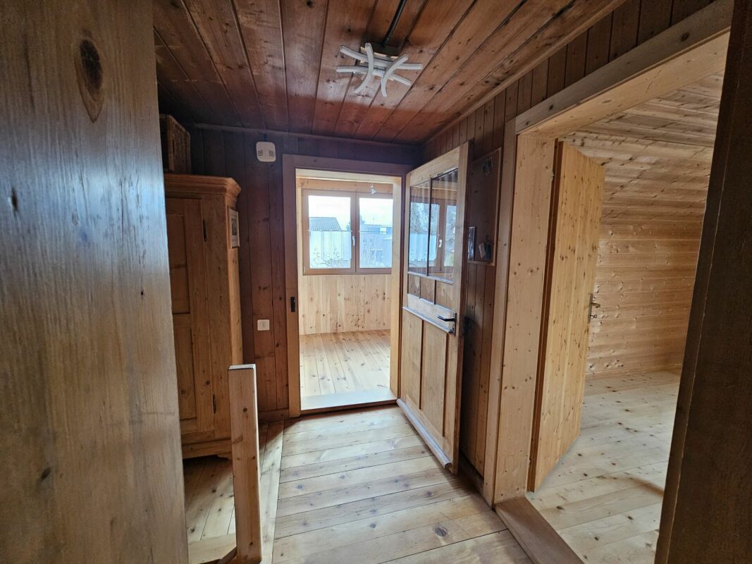 Holzvertäfelter Flur mit Blick in helle Nebenräume