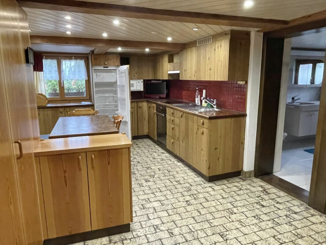 Rustikale Wohnküche mit Holzoptik und roter Rückwand