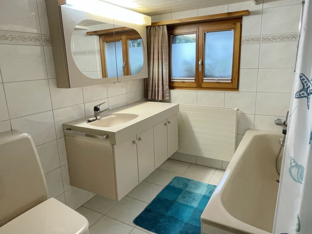 Badezimmer mit Holzfenster und Wanne