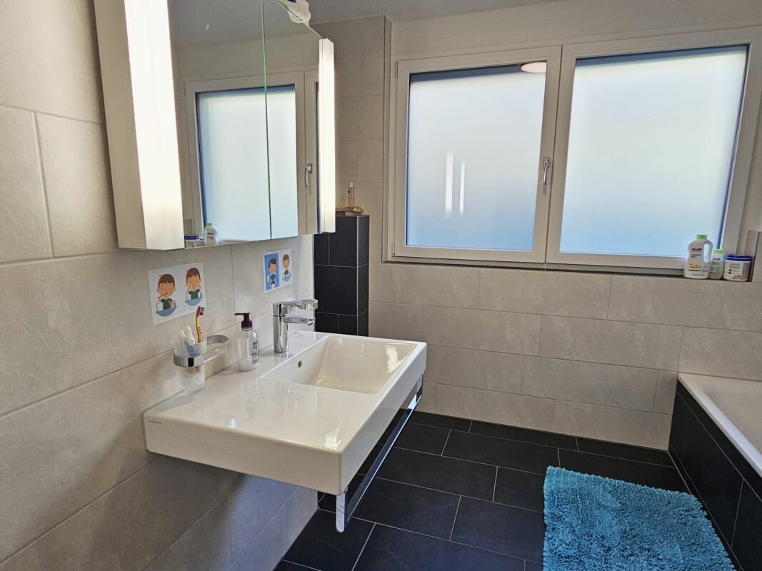 Modernes Badezimmer mit Badewanne und großem Fenster