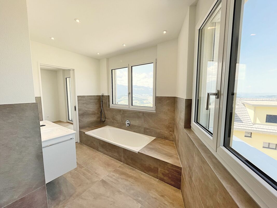 Modernes Badezimmer mit Eckbadewanne und Blick nach draußen