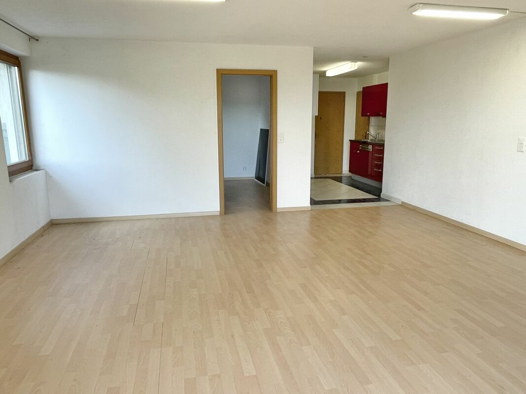 Leerer Wohnraum mit Blick in Küche und Nebenraum