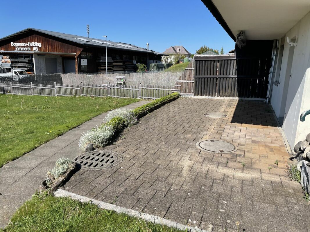 Außenbereich mit gepflasterter Terrasse und Garten