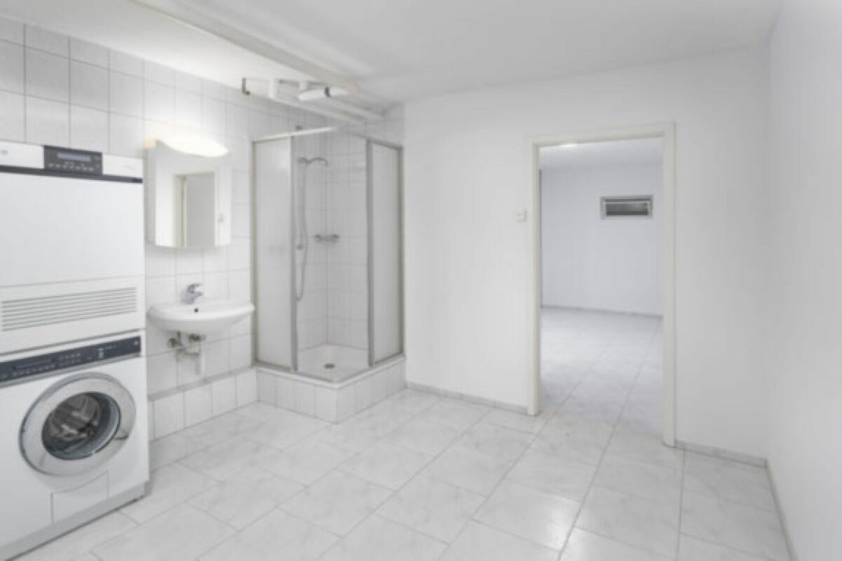 Badezimmer mit Waschmaschine und Dusche