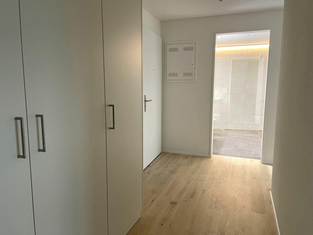Flur mit Einbauschrank und Blick in einen hell beleuchteten Nebenraum