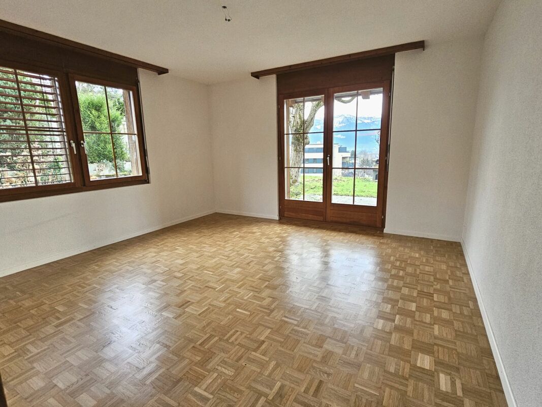Leerer Raum mit Parkett und Balkon-/Terrassentür