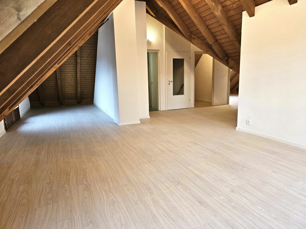 Dachgeschossraum mit sichtbaren Holzbalken