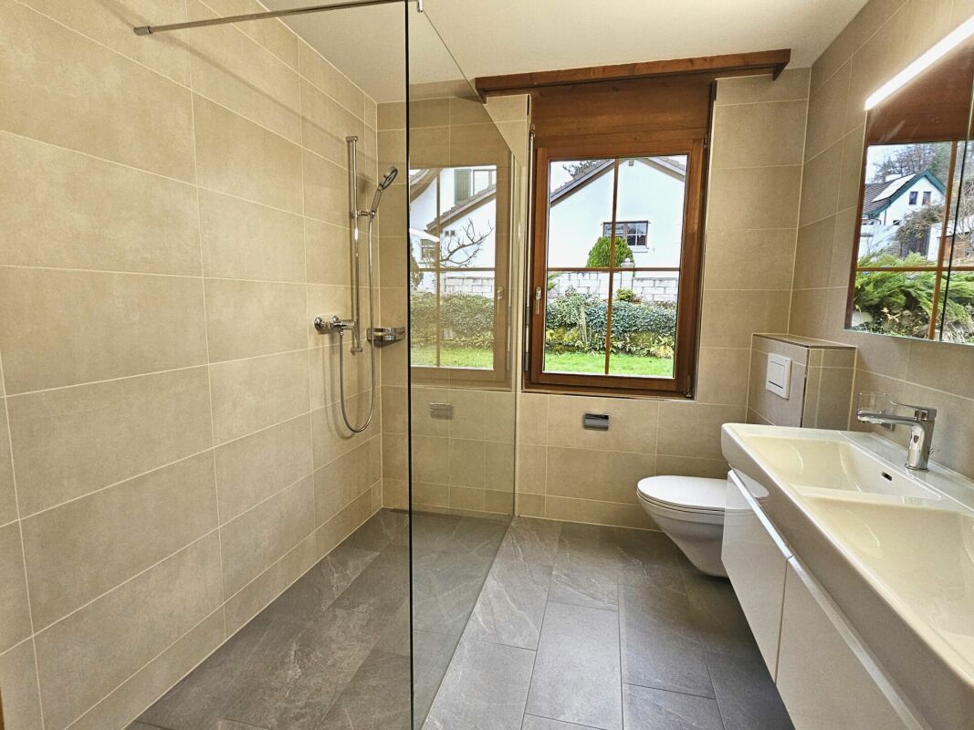 Modernes Badezimmer mit begehbarer Dusche und Fensterblick
