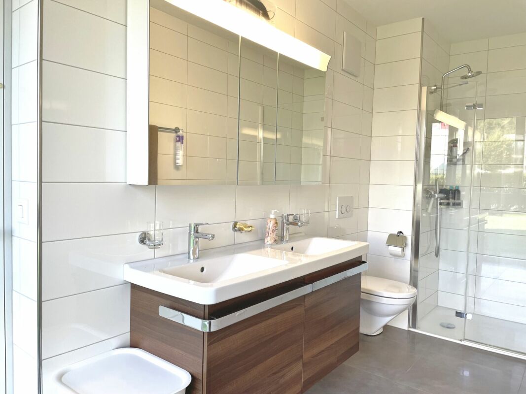 Modernes Badezimmer mit Doppelwaschtisch und Glasdusche