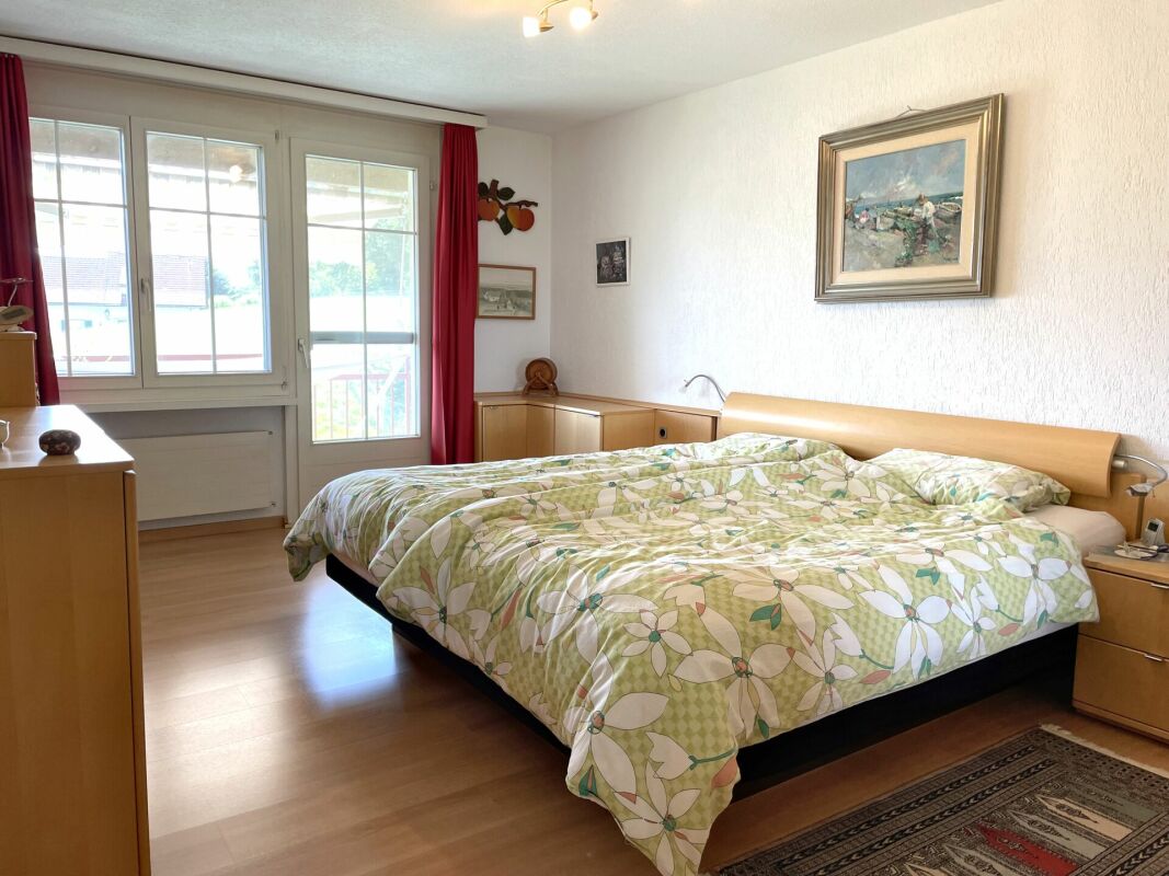 Helles Schlafzimmer mit Doppelbett und Balkonfenster