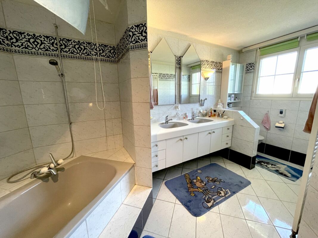 Badezimmer mit Doppelwaschtisch und Badewanne