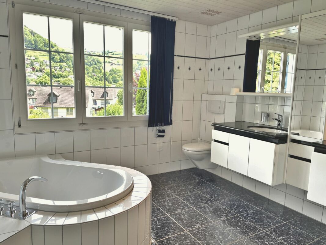 Badezimmer mit Whirlpool-Badewanne und Fensterblick