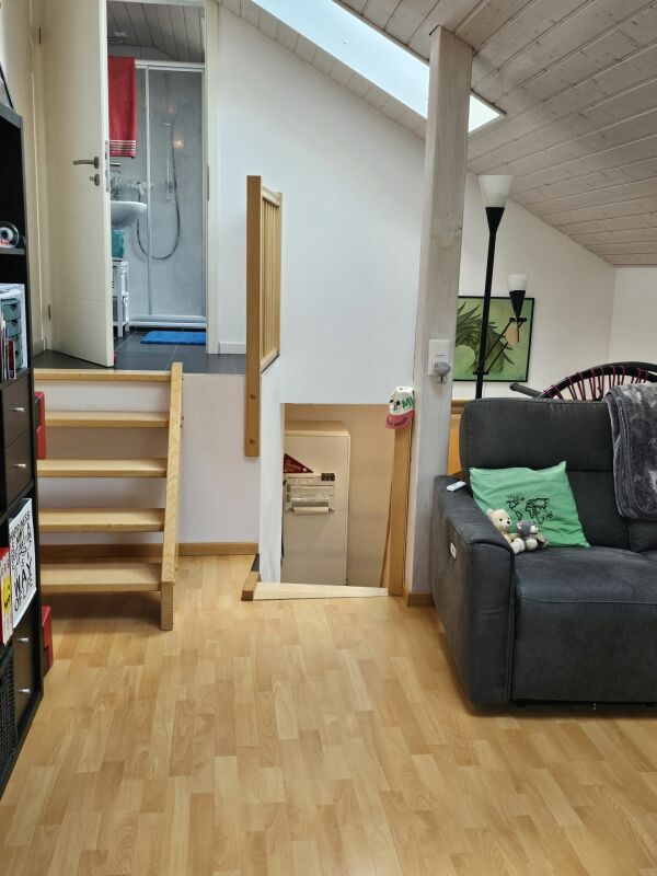 Dachgeschoss-Wohnbereich mit Treppe und Badezimmerzugang