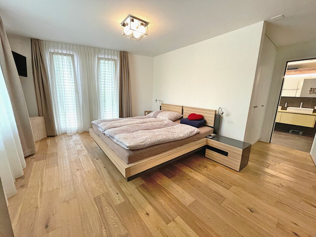Schlafzimmer mit Doppelbett und Blick in Richtung Bad/Ankleide