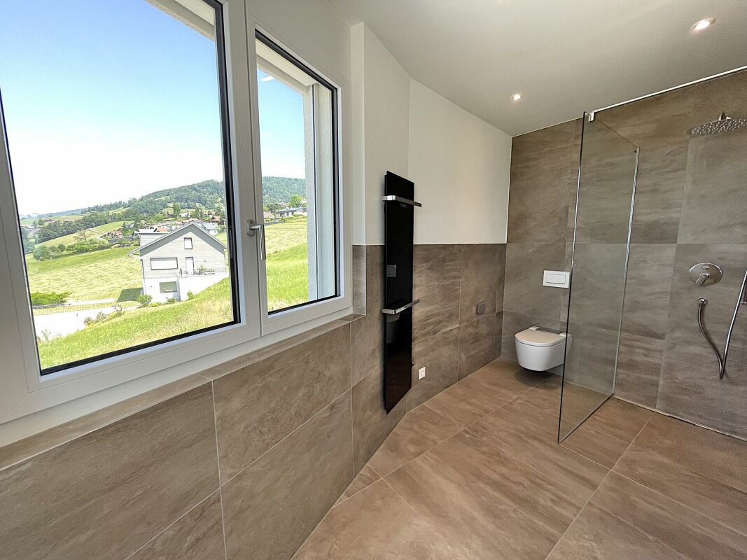 Modernes Badezimmer mit Panoramafenster und bodengleicher Dusche