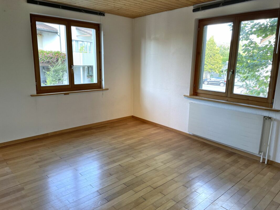 Heller leerer Raum mit Holzfenstern und Parkett