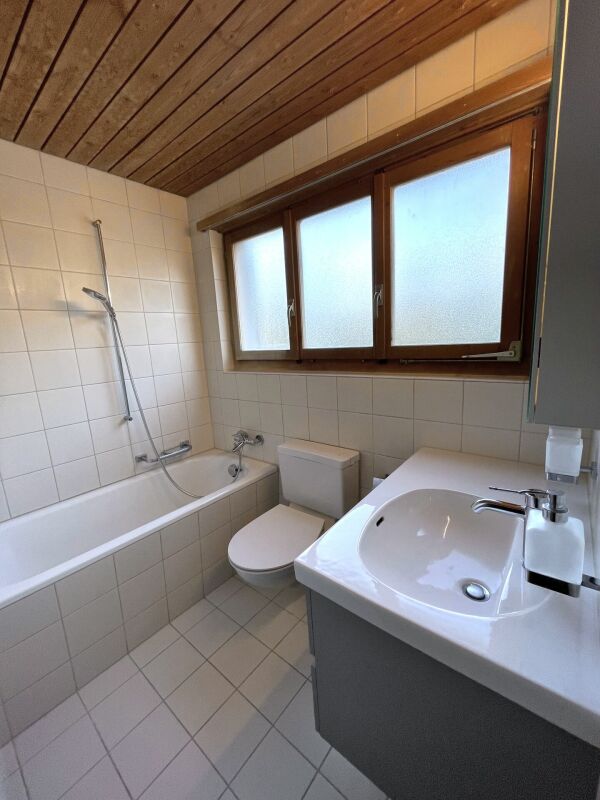 Badezimmer mit Wanne und Holzdecke