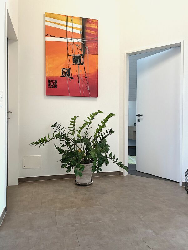 Moderner Flur mit Pflanze und Wandkunst
