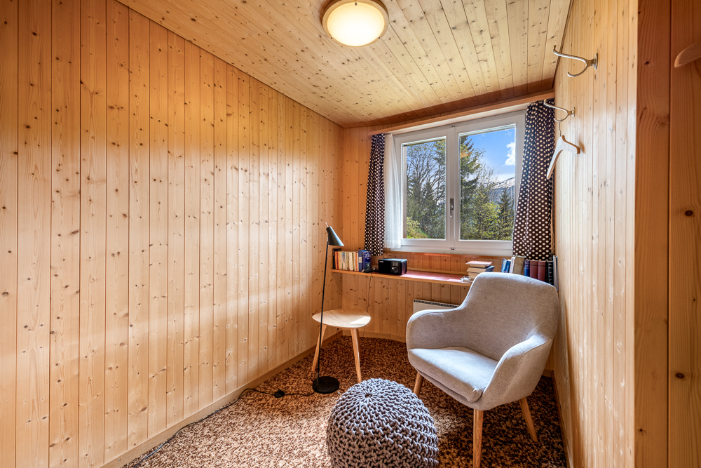 Holzverkleideter Innenraum mit Sitzplatz am Fenster