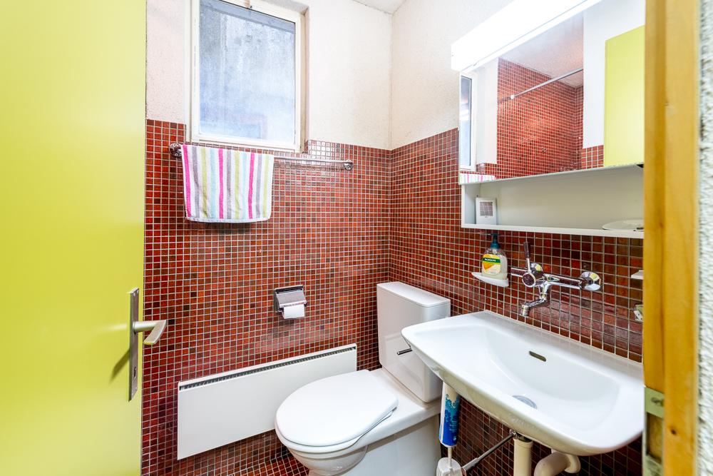 Kleines Badezimmer mit roter Mosaikverkleidung