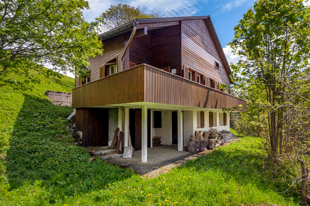 Holzhaus mit Balkon in grüner Hanglage