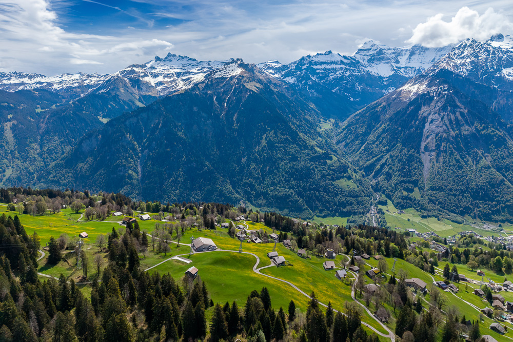 Alpine Berglandschaft mit Wiesen und Häusern