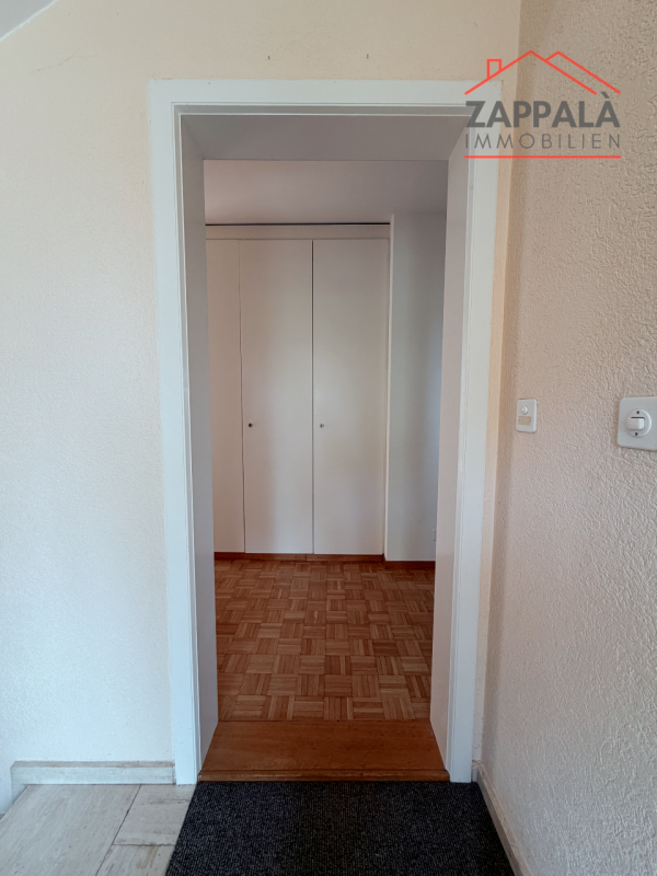 Flur mit Durchgang zu einem Raum mit Einbauschrank