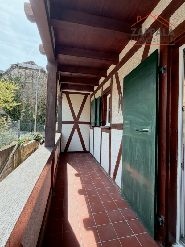 Überdachter Balkon mit Fachwerk und Terrakottafliesen