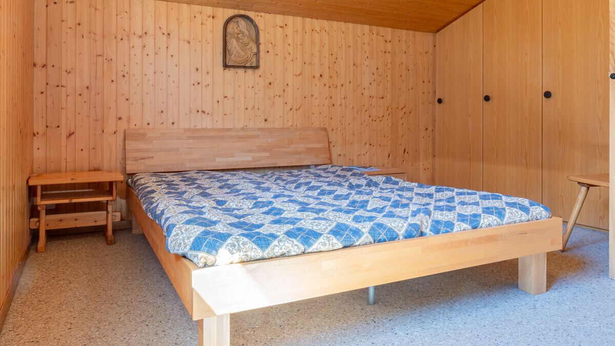 Holzverkleidetes Schlafzimmer mit Doppelbett