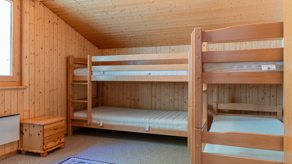 Dreier-Stockbett in holzverkleidetem Schlafzimmer
