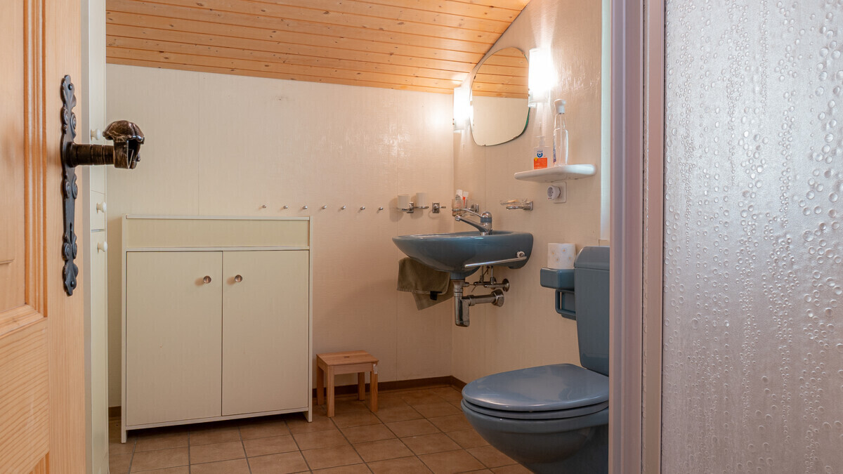 Kleines Bad mit blauem WC und Waschtisch