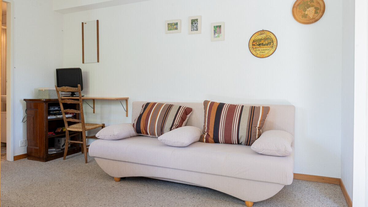 Wohnzimmer mit Sofa und Schreibtischecke