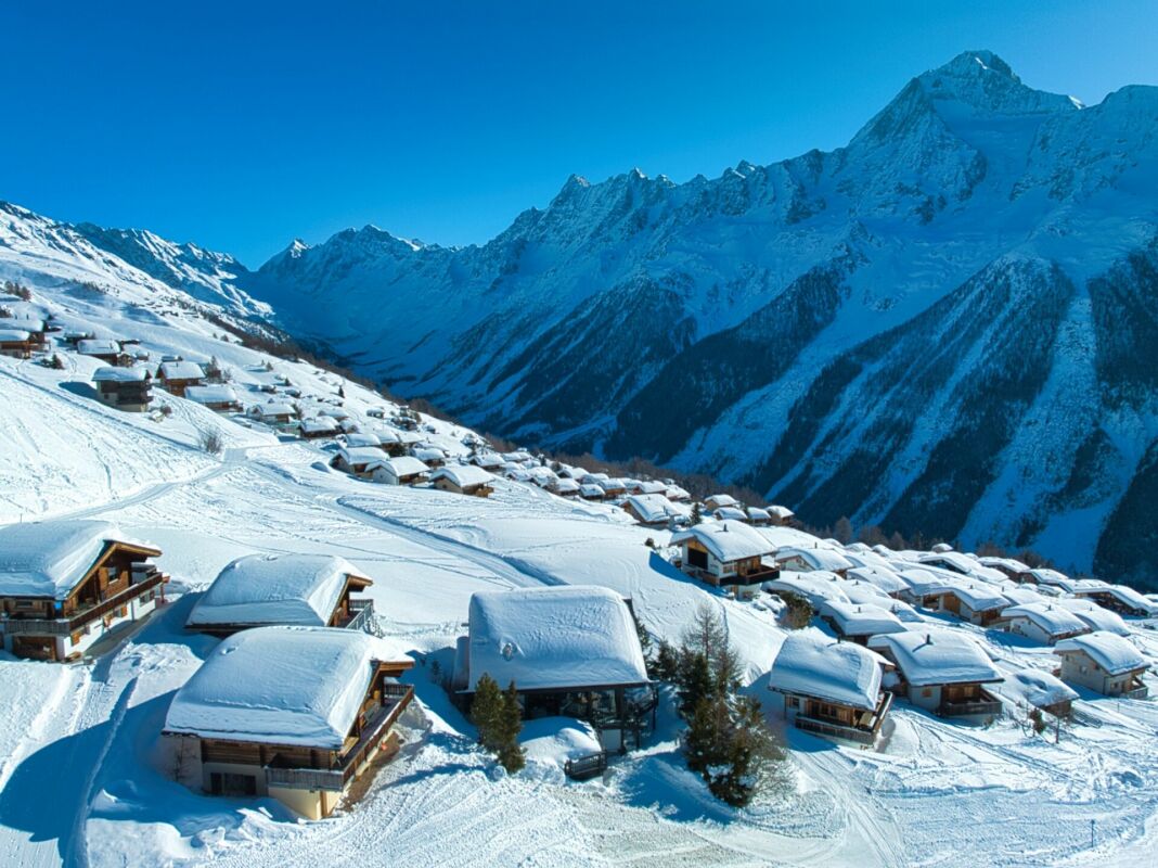 Schneebedeckte Berghäuser in alpiner Landschaft