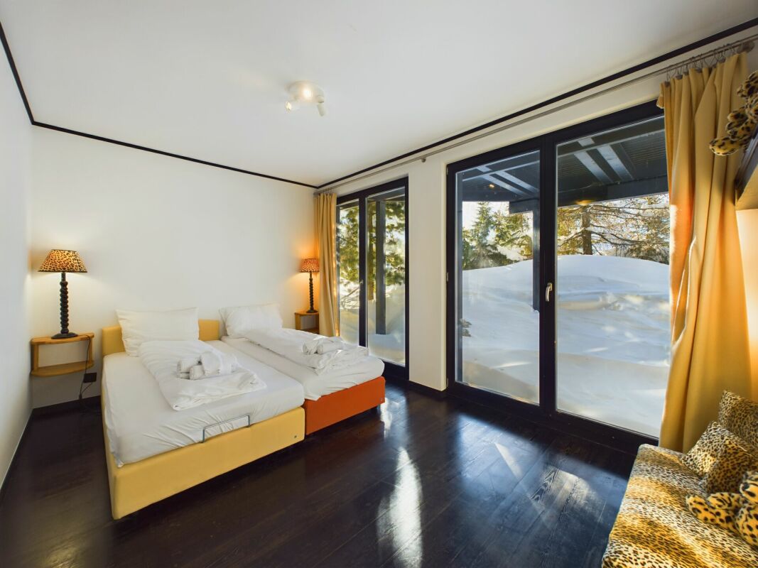 Schlafzimmer mit großen Fensterfronten und Schneeblick