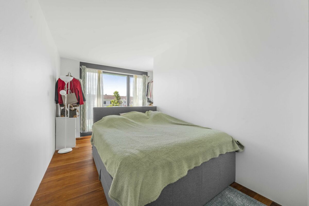 Schmales Schlafzimmer mit Bett und Fenster