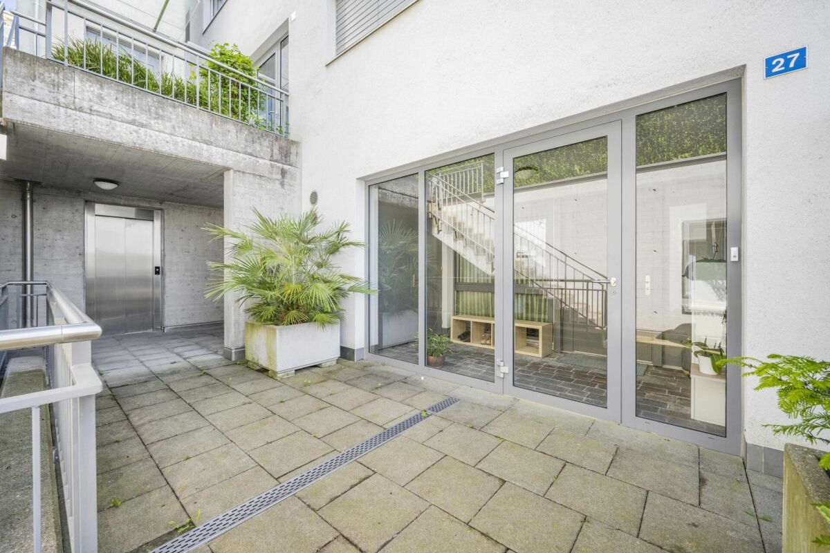 Außenbereich vor moderner Wohnanlage mit Glasfront