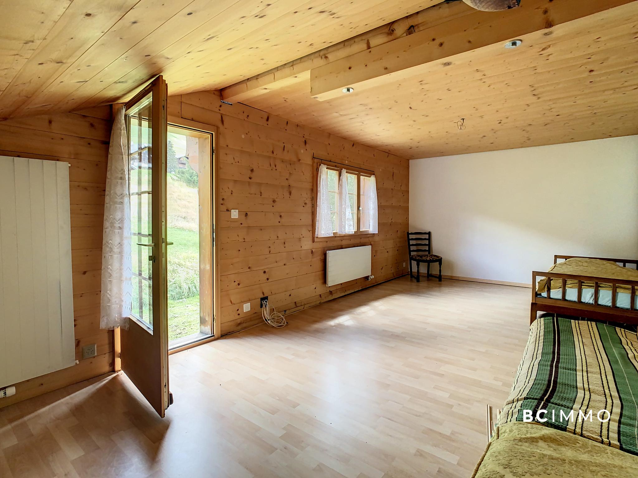 Helles Holzschlafzimmer mit offener Tür zum Garten