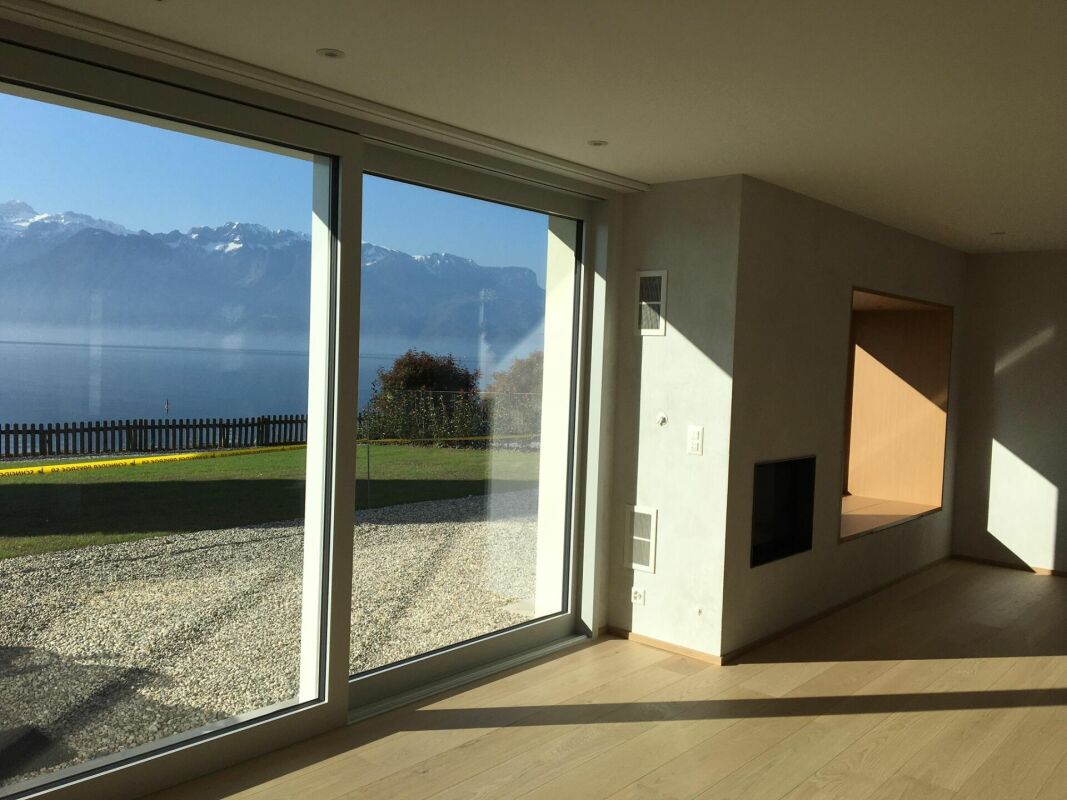 Wohnraum mit Panoramafenster und Seeblick