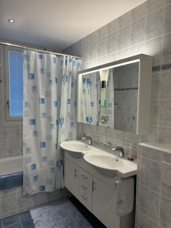 Badezimmer mit Doppelwaschtisch und Badewanne