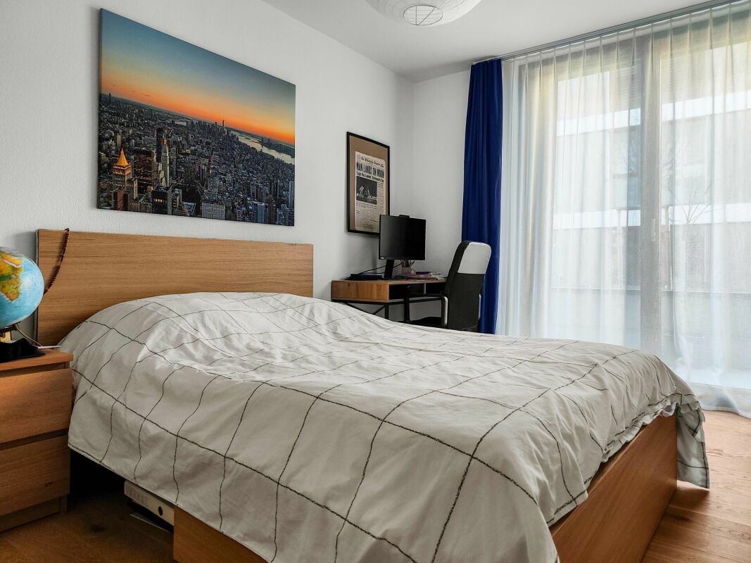 Schlafzimmer mit Bett und Fensterfront