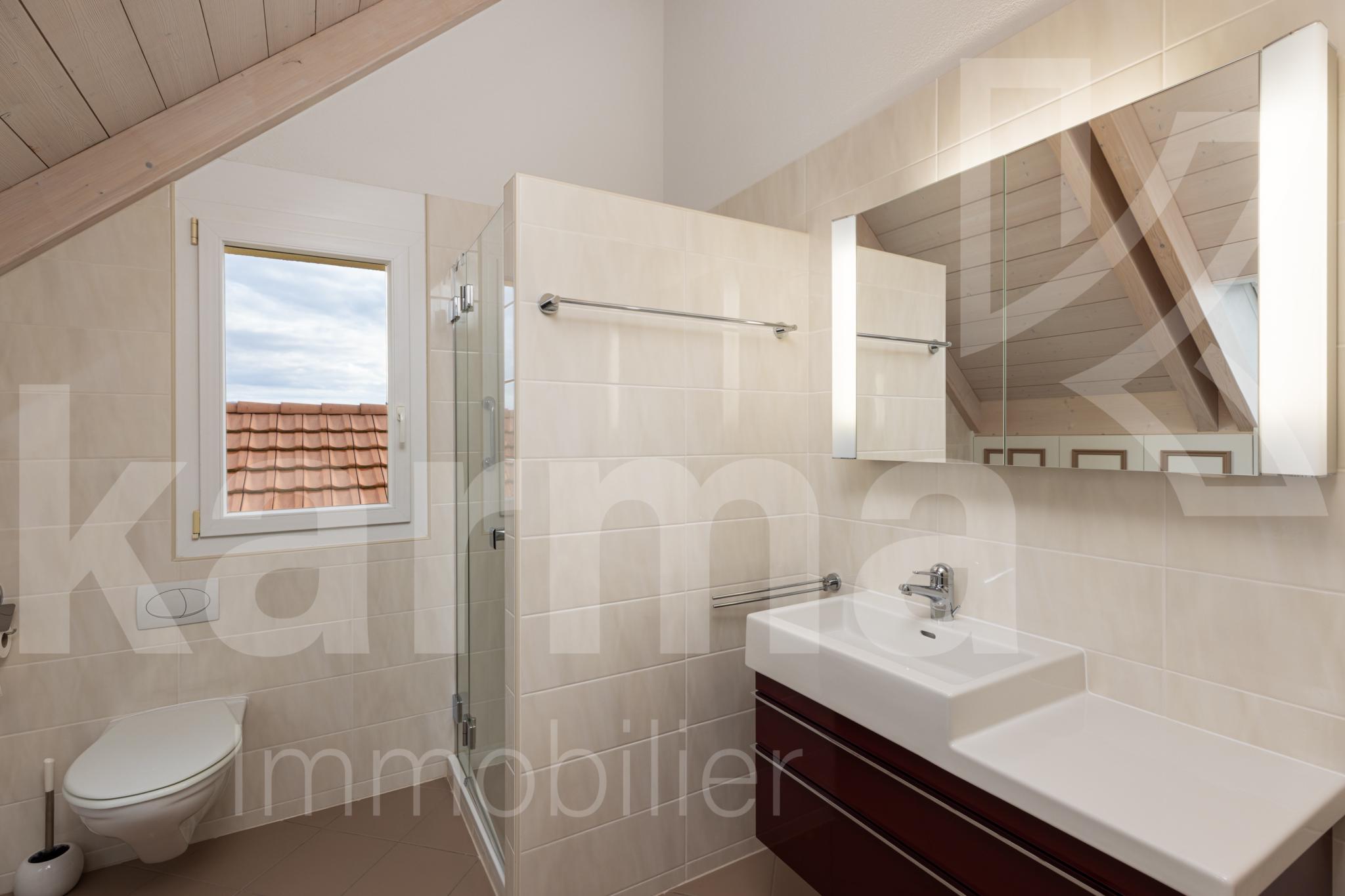 Helles Dachgeschoss-Badezimmer mit Fenster und Waschtisch