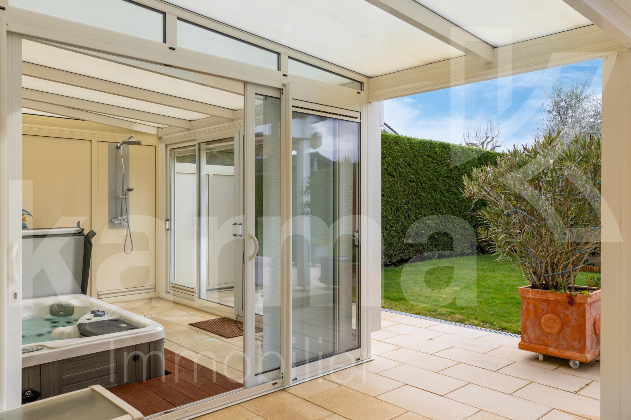 Überdachte Terrasse mit Whirlpool und Gartenblick